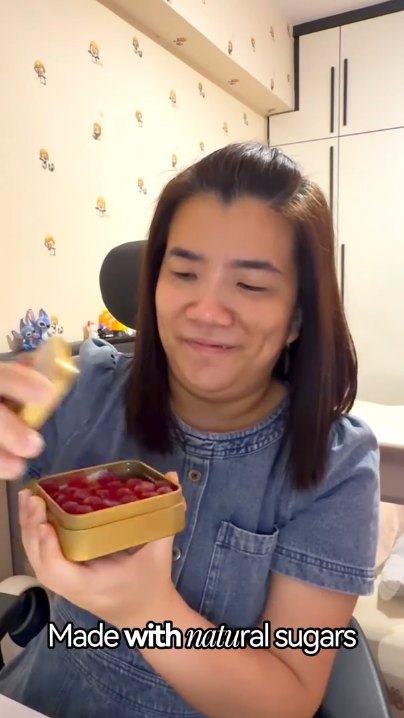 Creator holding an open tin of Everything Good Mint Chewy Candy